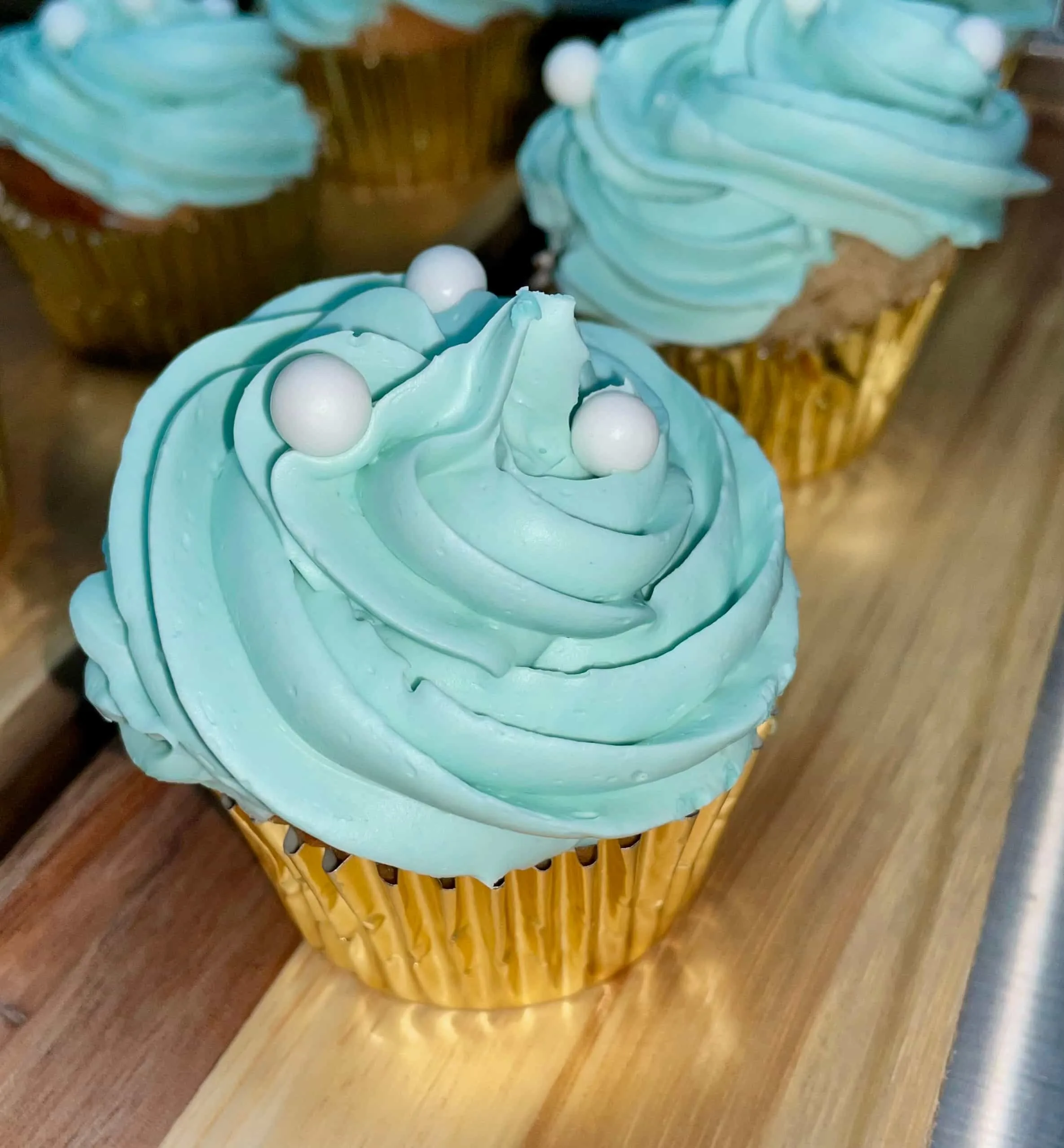Cupcakes caseros hechos por la Pilareta, son azules y llevan bolitas blancas en la parte superior.