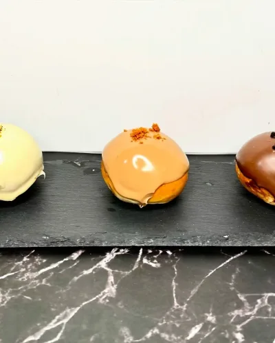 Bombas rellenas caseras hechas por la Pilareta y decoradas con cremas distintas y decoradas en la parte superior.